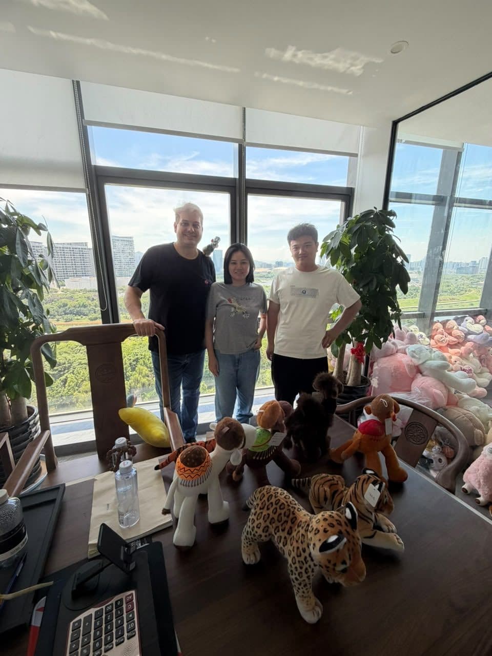 Equipe da M.Cruz no escritório na China, com amostras de pelúcias sobre a mesa